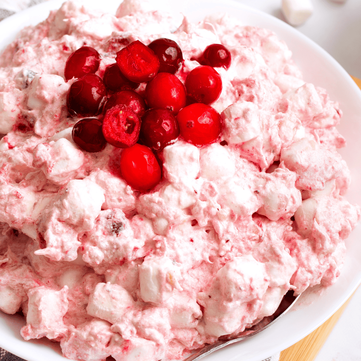 A bowl of cranberry fluff topped with whole cranberries.