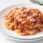 Crock pot spaghetti on a plate topped with Parmesan cheese.