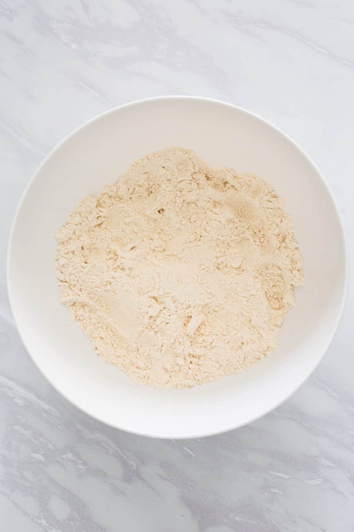 large white bowl of all-purpose flour, baking powder and salt.