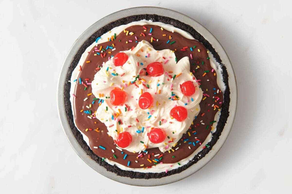 Ice cream pie with hot fudge, whipped cream, cherries, and sprinkles.