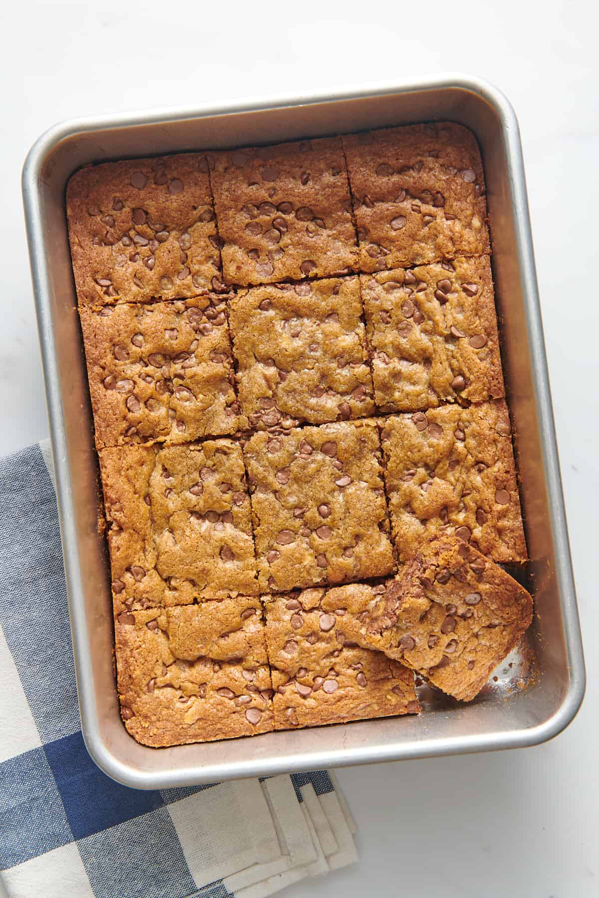 top down image of toll house chocolate chip cookie bars cut into 12 squares and sitting in a 9x13 baking pan.