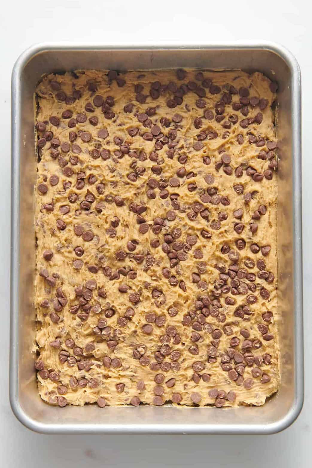 toll house chocolate chip cookie dough pressed into a 9x13 baking dish.