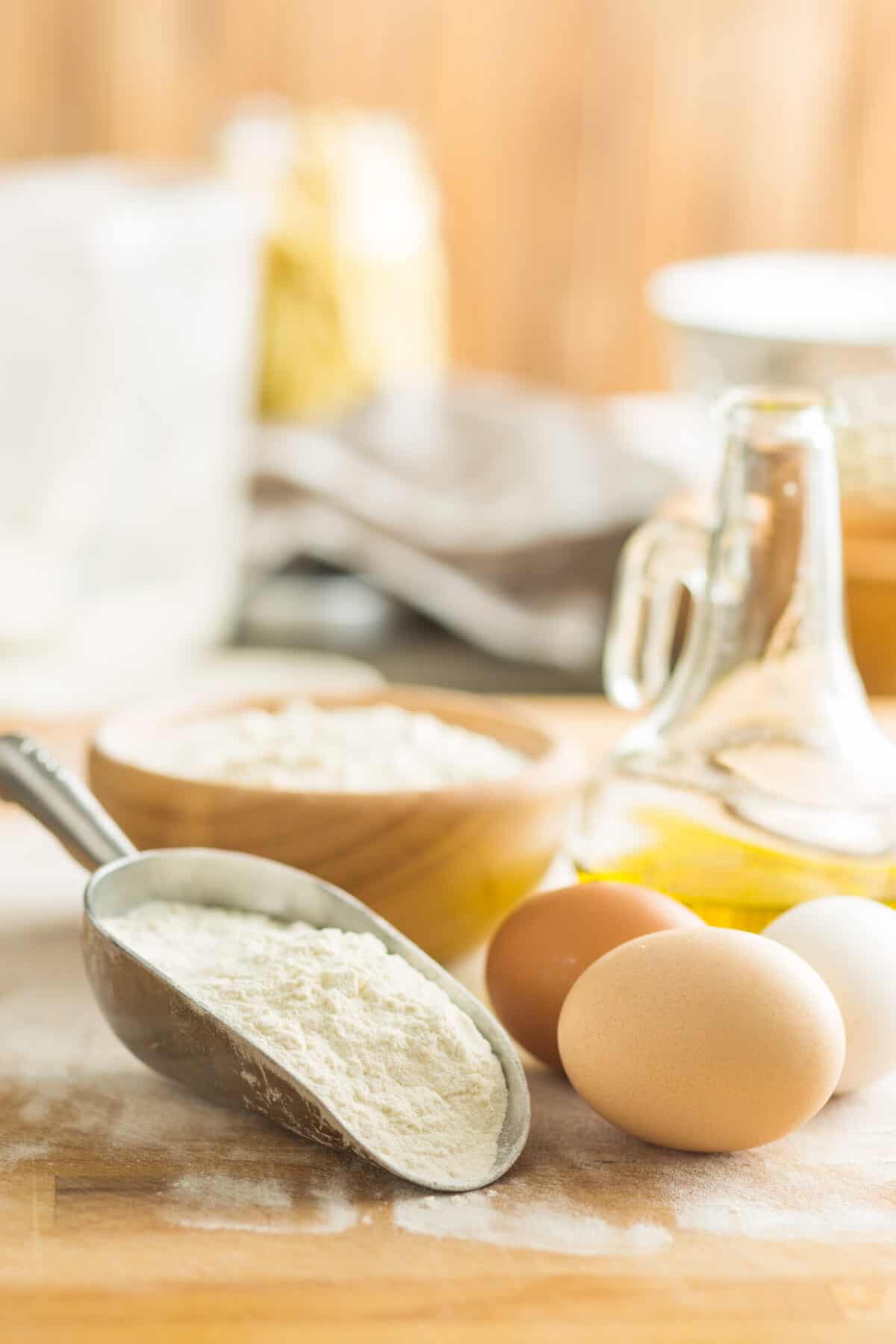 White flour and eggs on wooden table.