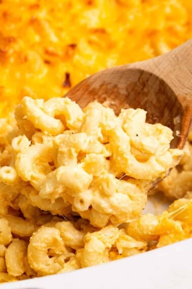 A wooden spoon lifting a scoop of Chick-fil-A macaroni and cheese.