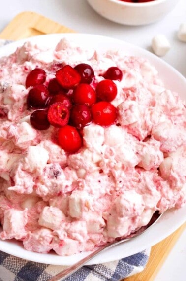 A bowl of cranberry fluff topped with fresh cranberries.