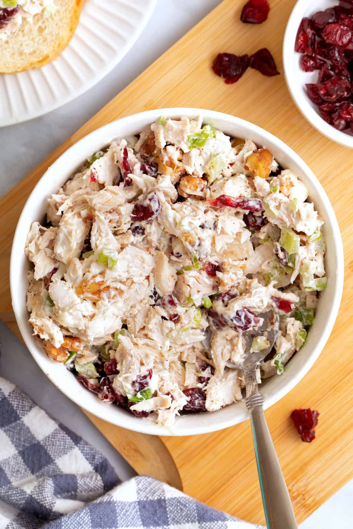 top down image of cranberry chicken salad served in a white round bowl. 
