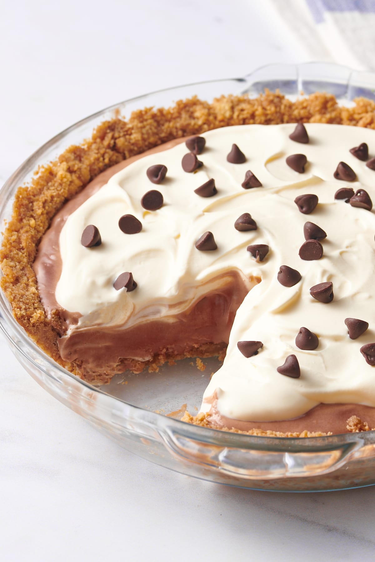 close up image showing the cross section of chocolate pudding pie with graham cracker crust. 