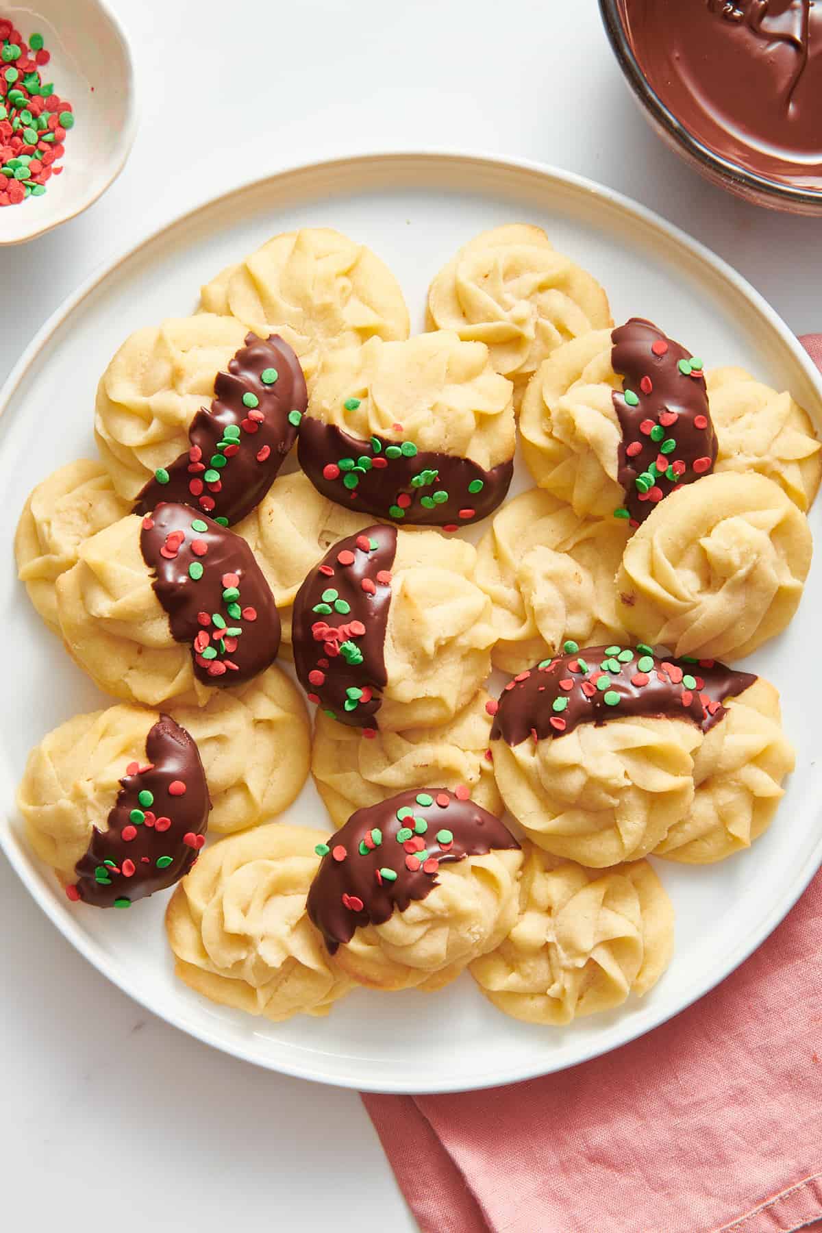 top down image of a large round white plate of christmas butter cookies. 