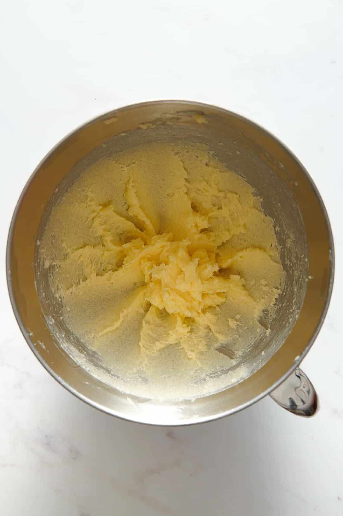 butter and sugar creamed in a stainless steel mixing bowl. 
