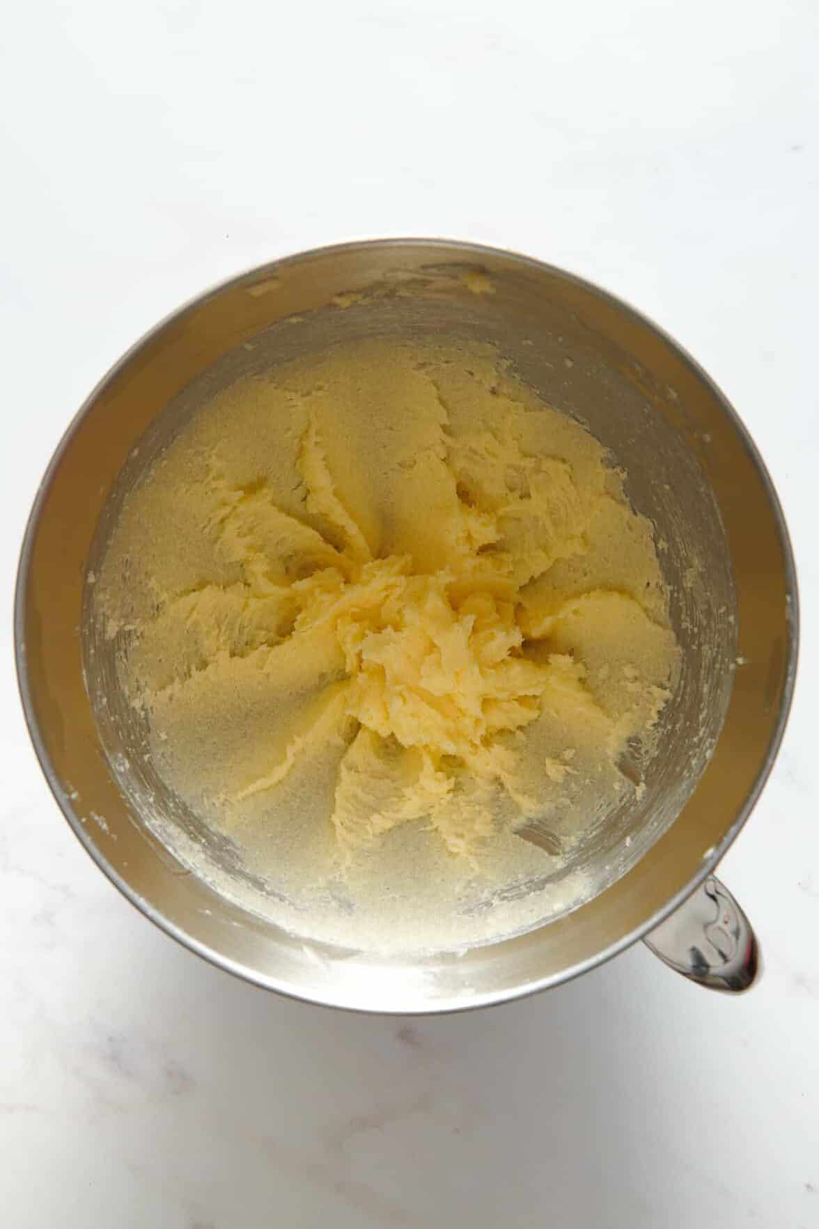 butter and sugar creamed in a stainless steel mixing bowl.
