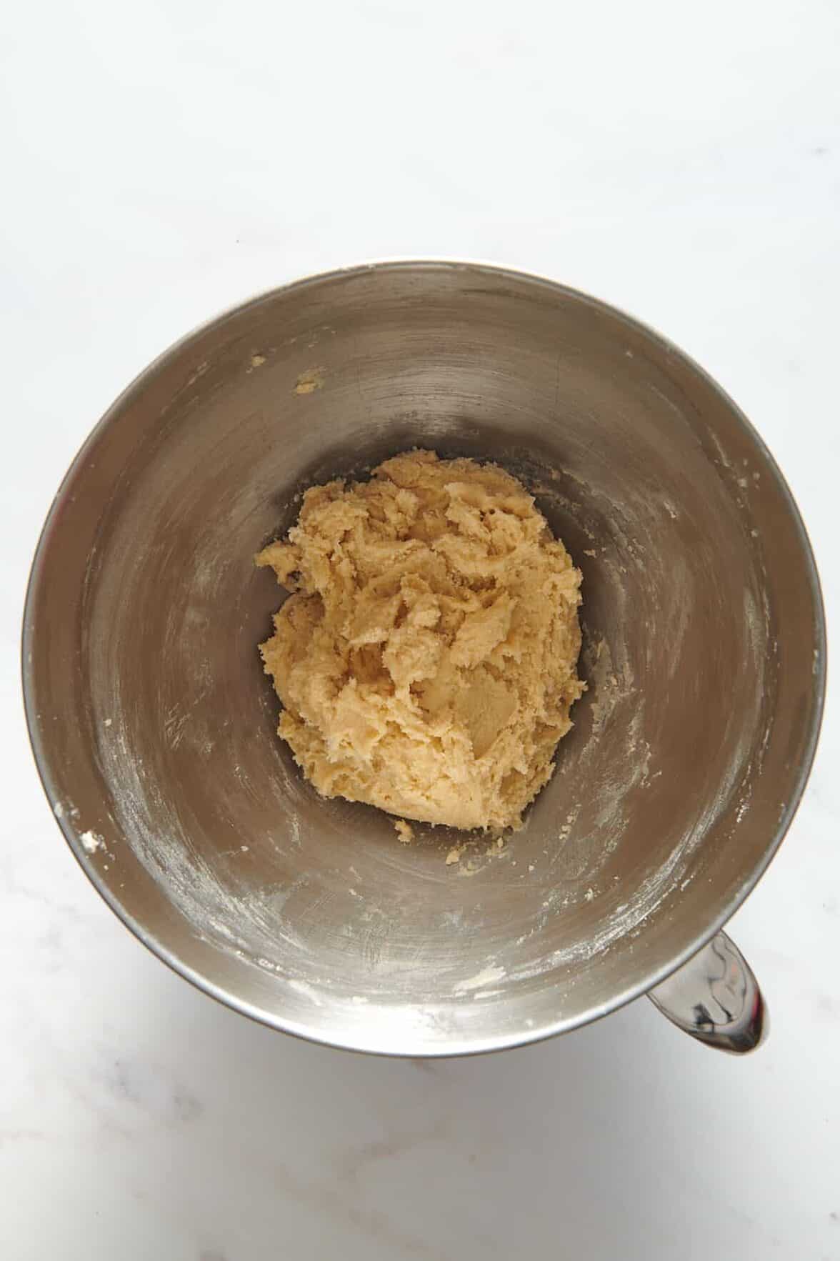 butter cookie dough sitting in a stainless steel mixing bowl. 