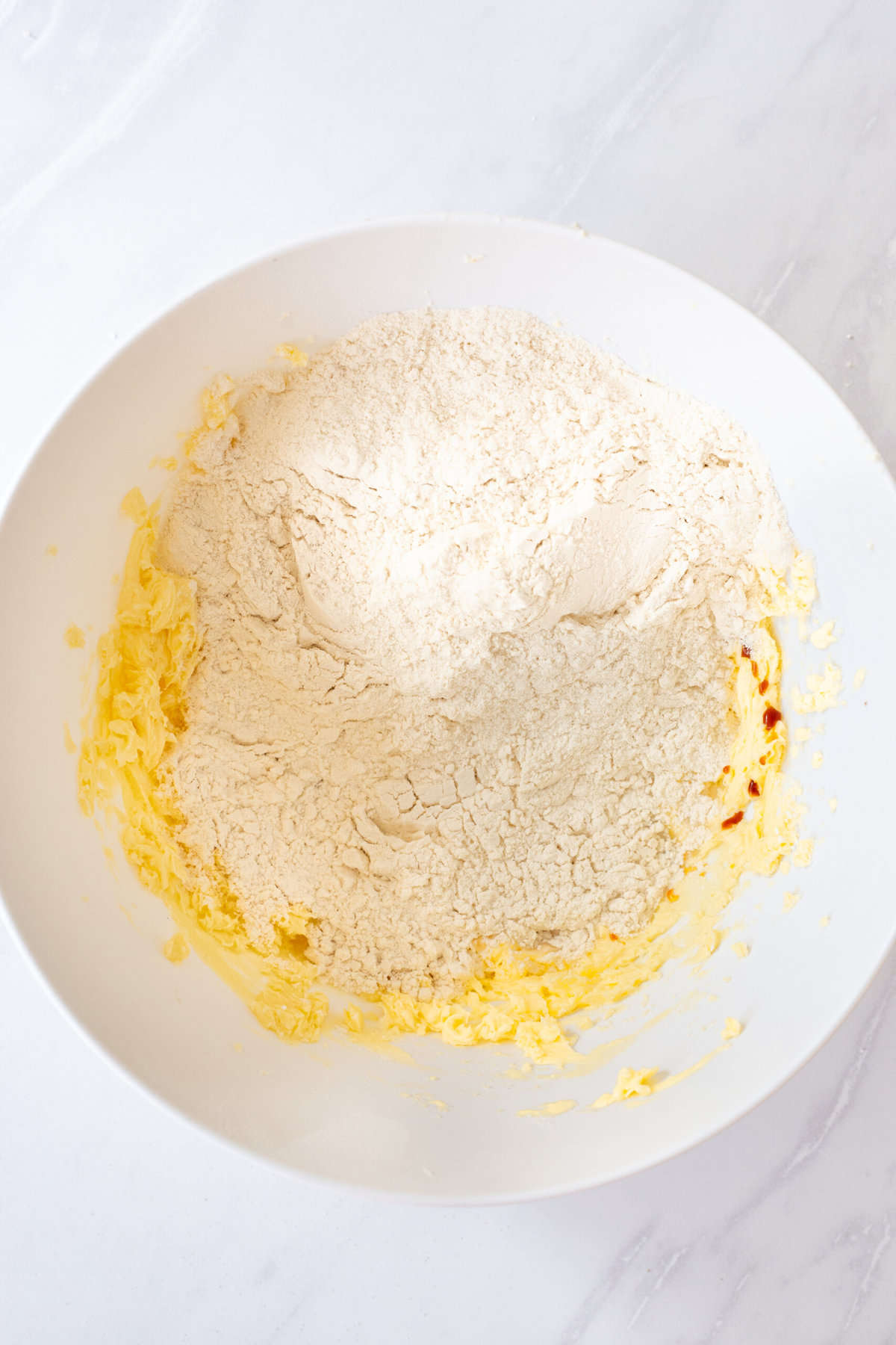 softened butter and sugar combined with all-purpose flour in a white large bowl. 