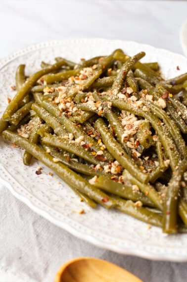 A platter of Instant Pot green beans topped with crushed almonds.