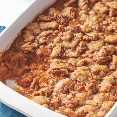 Sweet potato souffle in a casserole dish with a serving missing.