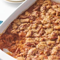 Sweet potato souffle in a casserole dish with a portion missing.