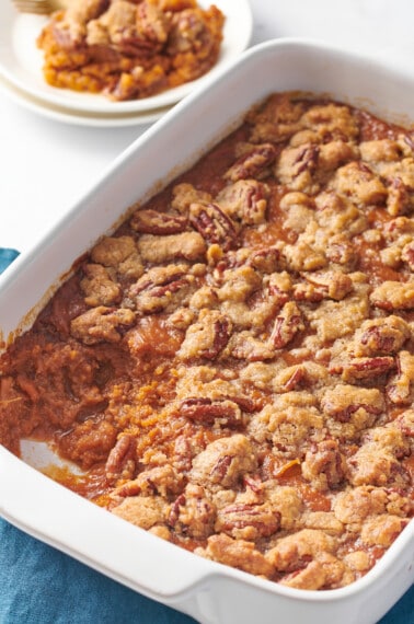 Sweet potato souffle in a casserole dish with a portion missing.