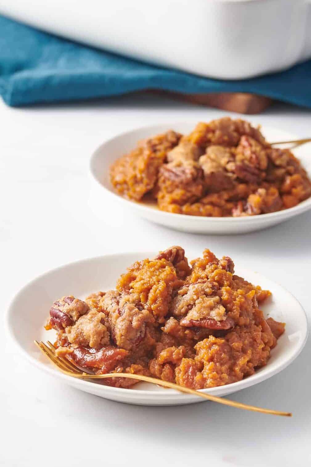 two shallow plates with a serving of sweet potato souffle.