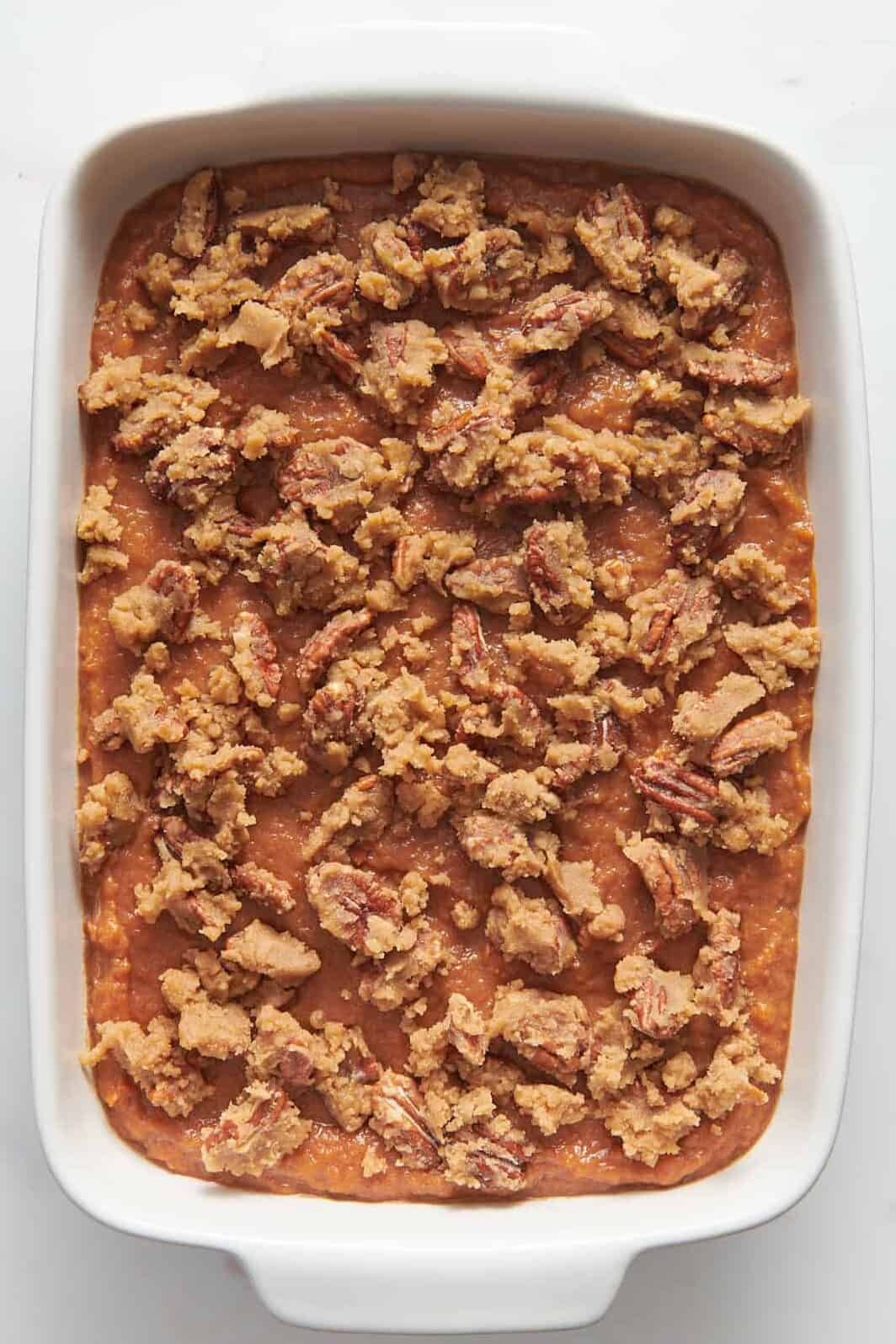 sweet potato souffle filling topped with a pecan mixture topping sitting in a 9x13 casserole dish. 