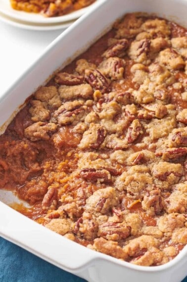 Sweet potato souffle in a casserole dish with a portion missing.