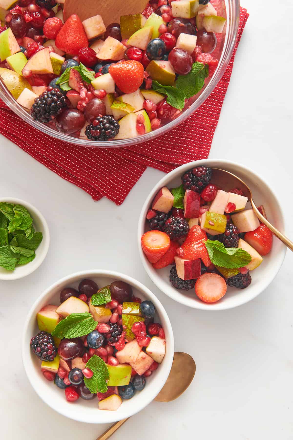 top down image of three bowls of christmas fruit salad. 