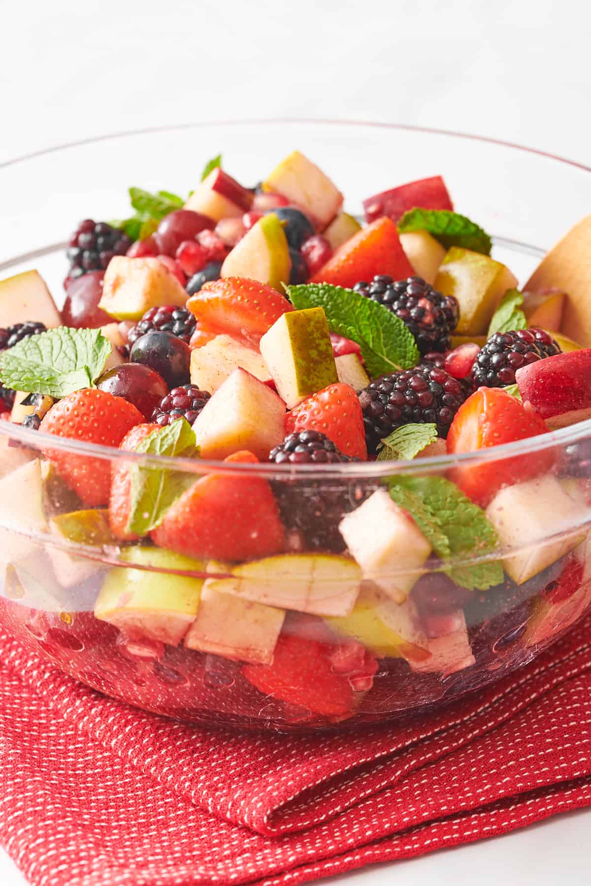 close up image of christmas fruit salad served in a large glass bowl.