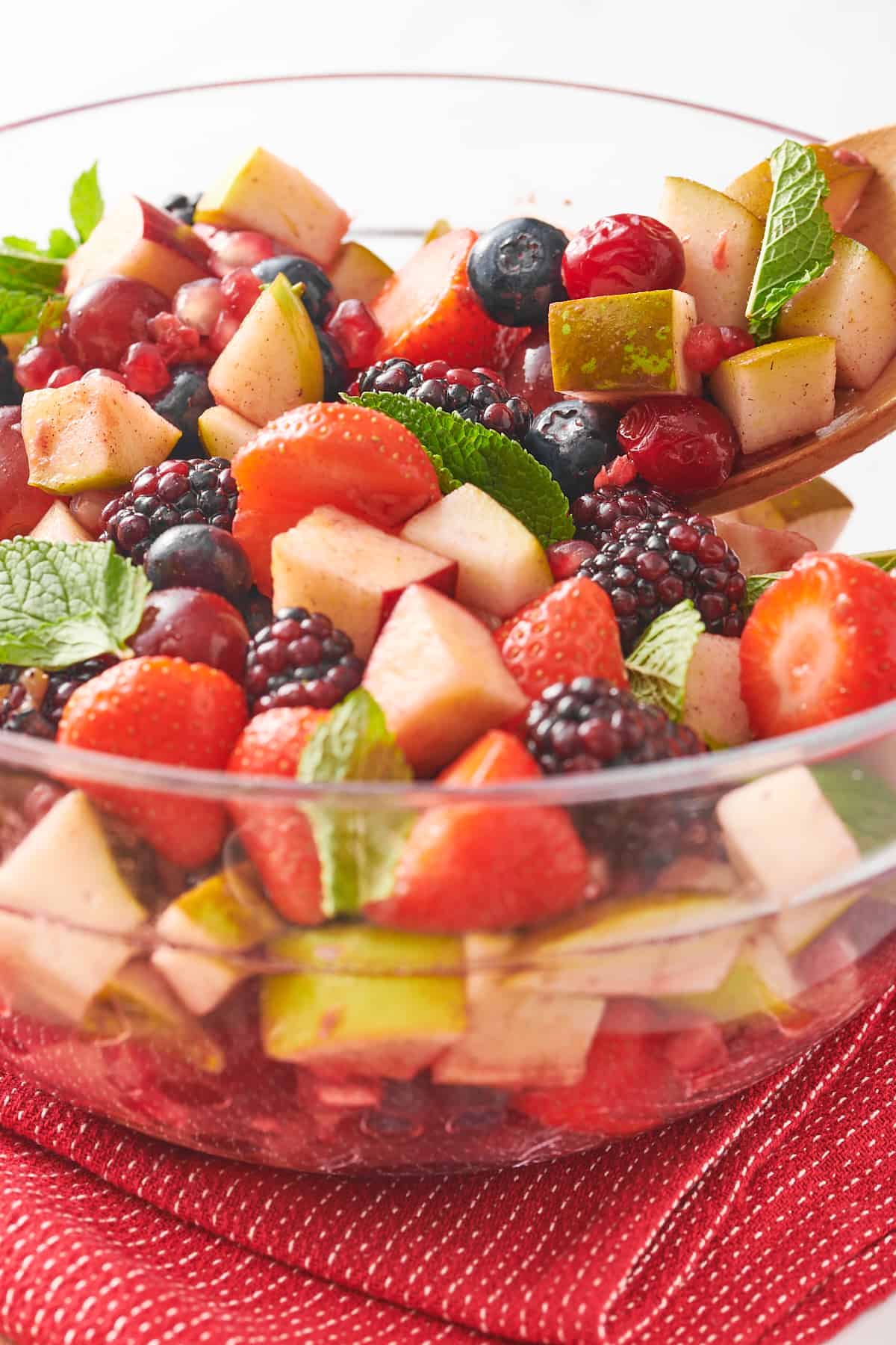 close up image of christmas fruit salad served in a large glass bowl. 
