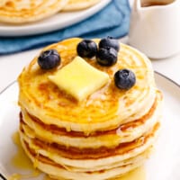 A stack of classic Bisquick pancakes topped with butter and blueberries.