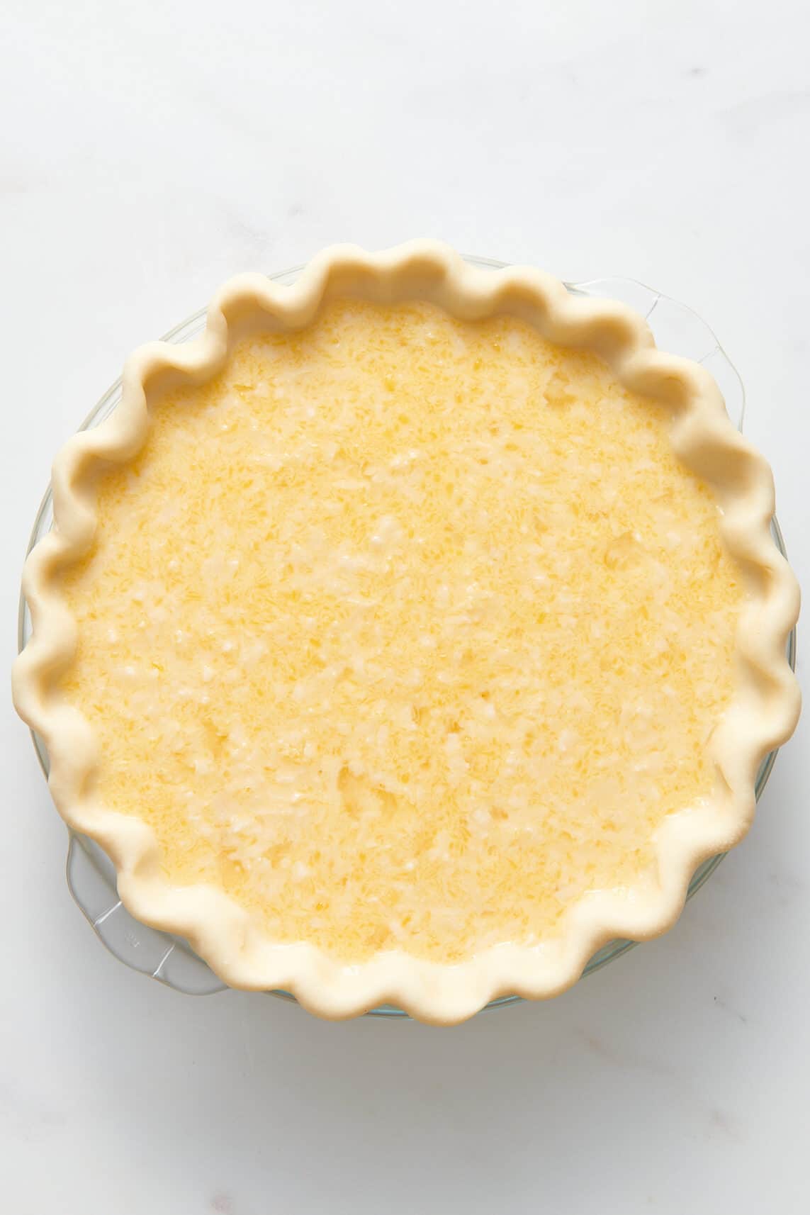 top down image of unbaked old fashion coconut pie.