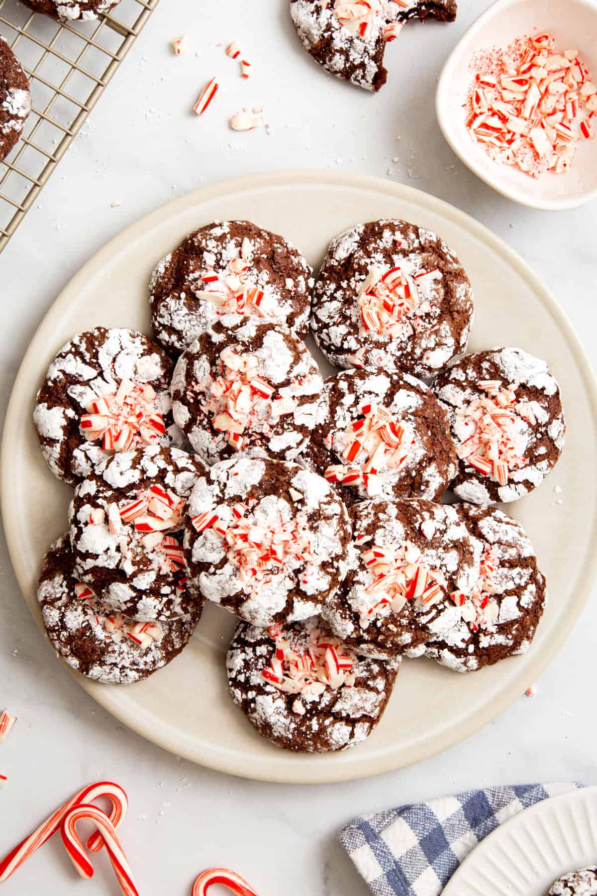 top down image of a beige plate with a pile of chocolate mint crinkle cookies. 