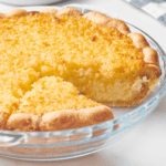 An old-fashioned coconut pie with a slice missing.