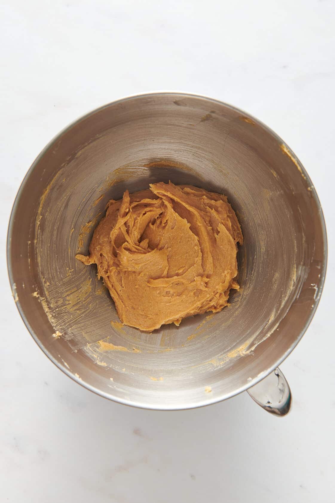 peanut butter cookie dough sitting in a large stainless steel mixing bowl. 