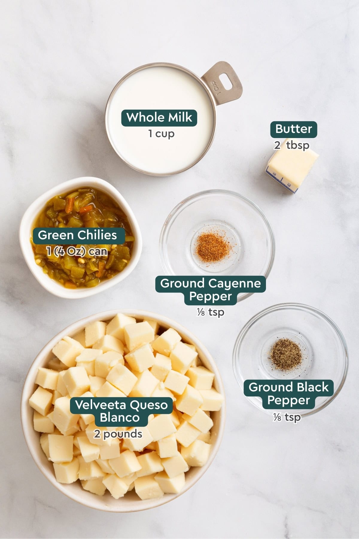 Ingredients for velveeta queso blanco, including milk, butter, cayenne, chilies, pepper, and velveeta.