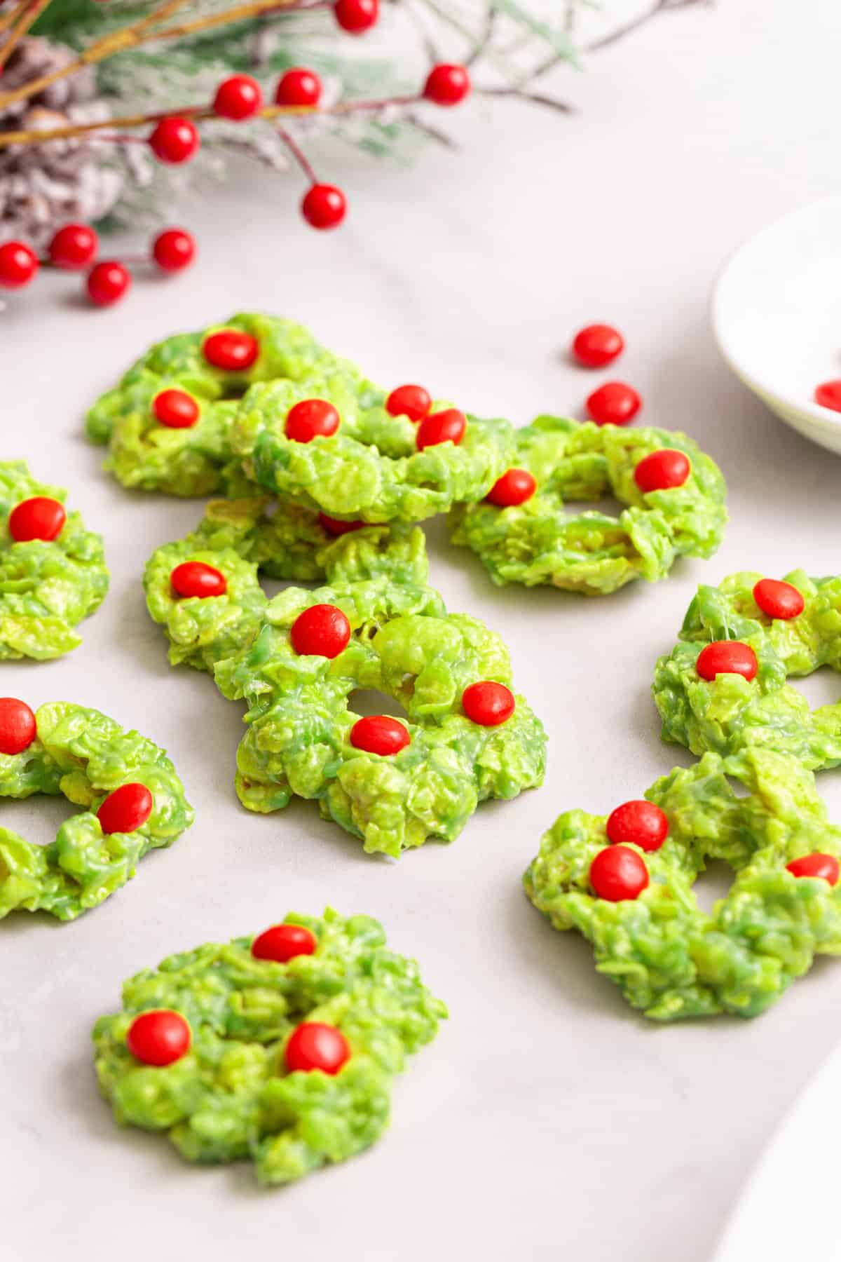 Christmas Wreath Cornflake Cookies sitting on a white kitchen countertop.