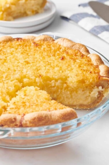 An old-fashioned coconut pie with a slice missing.