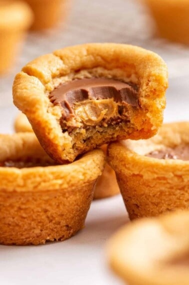 Peanut butter cookie cups with one missing a bite.