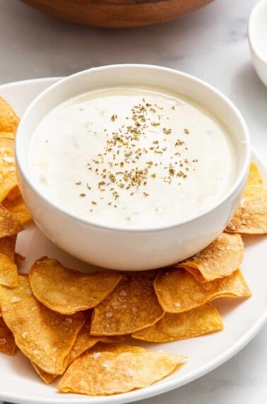 A bowl of Velveeta queso blanco recipe surrounded by tortilla chips.