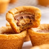 Peanut butter cookie cups with one missing a bite.