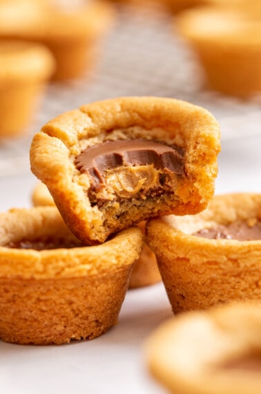 Peanut butter cookie cups with one missing a bite.