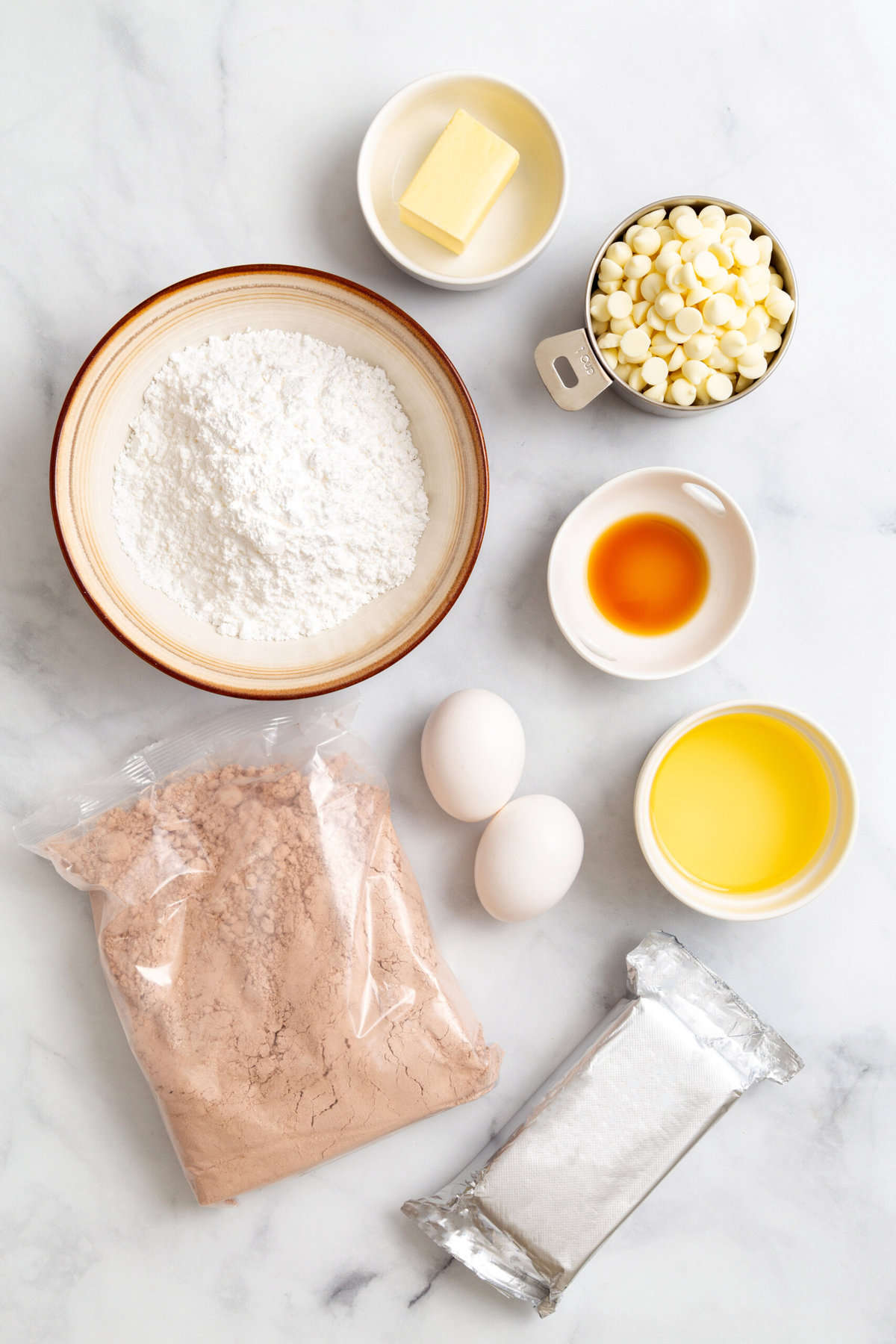 ingredients to make dense red velvet brownies with white chocolate chips and cream cheese frosting.