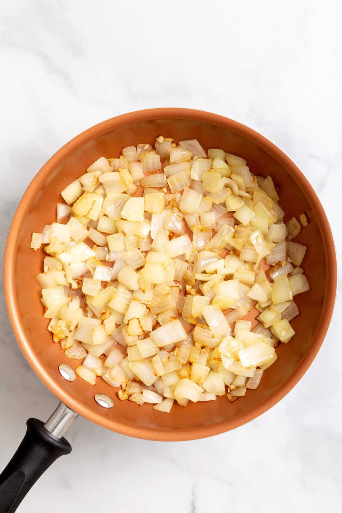 top down image of chopped onions in a skillet. 