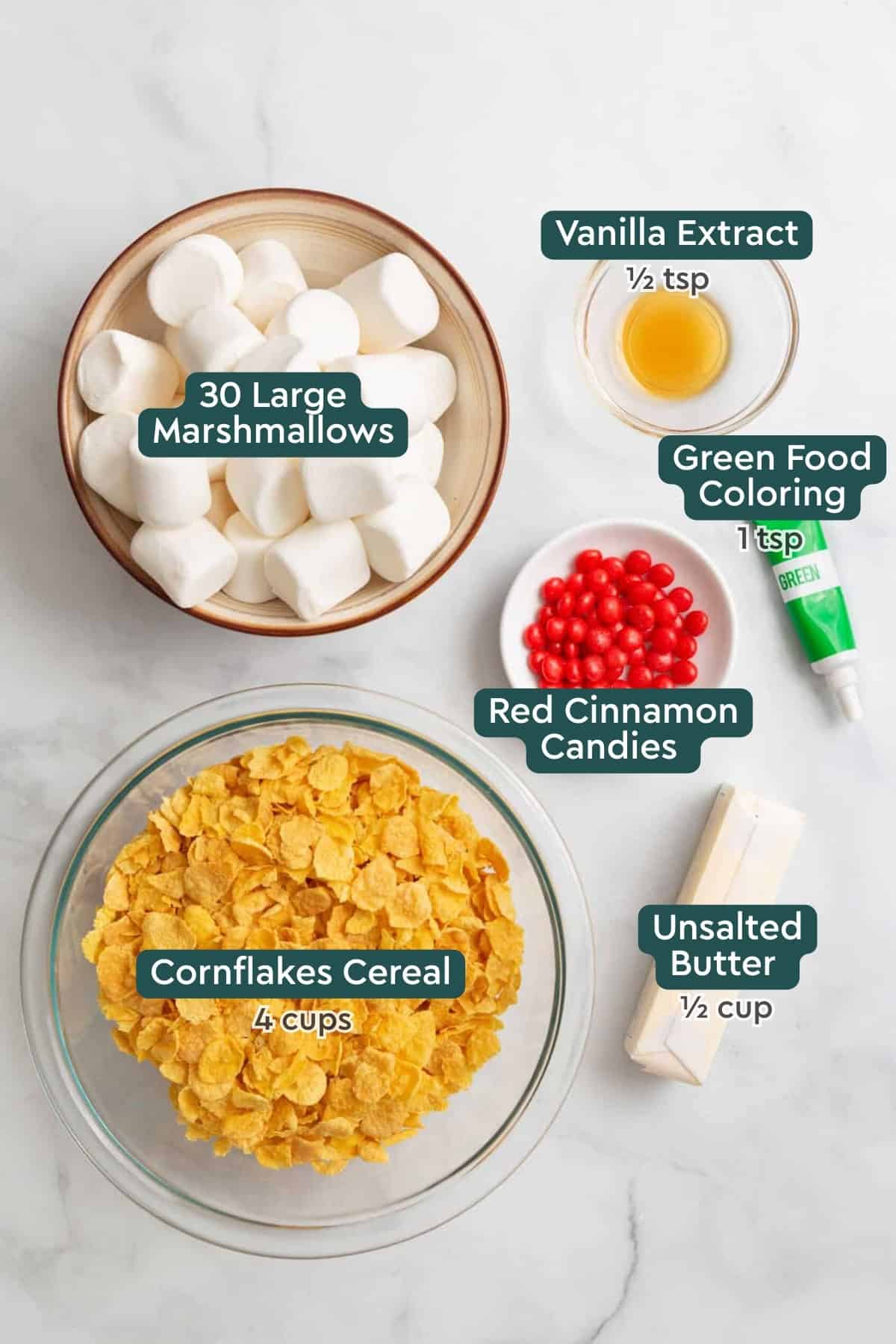 Ingredients for Christmas wreath cookies, including marshmallows, vanilla, food coloring, cinnamon candies, butter, and corn flakes.