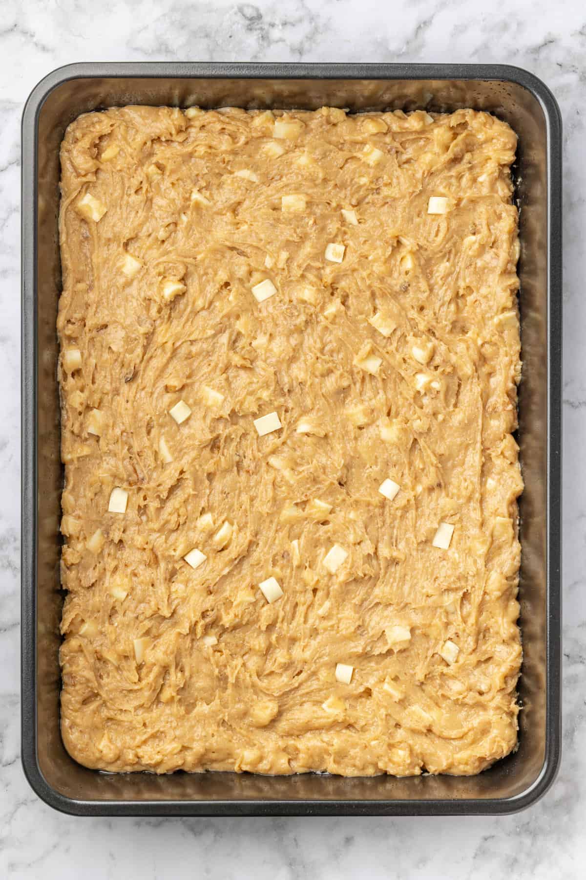top down image of a 9x13 baking dish bowl with blonde brownie batter prepared and ready to bake. 