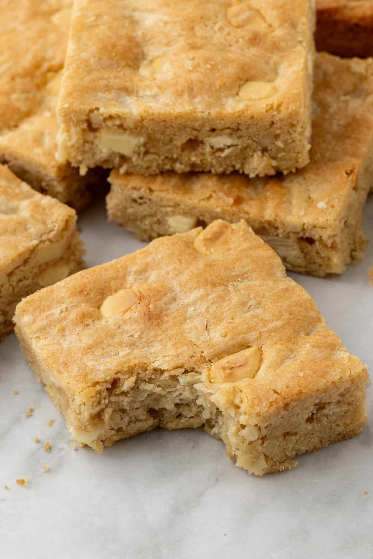 close up image of a blonde brownie with a bite taken out of it.