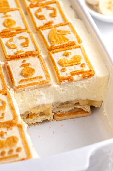 Chessman banana pudding in a baking dish with a serving missing.