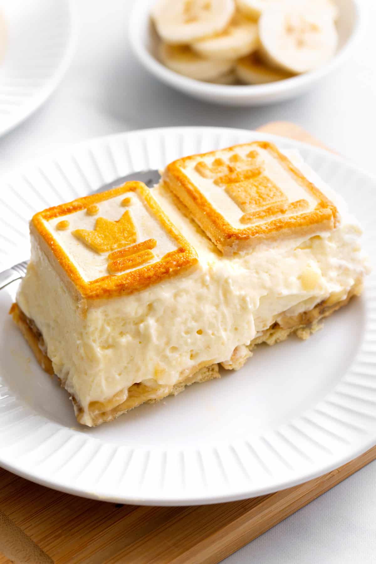 close up image of a serving of chessman banana pudding sitting on a white round plate. 