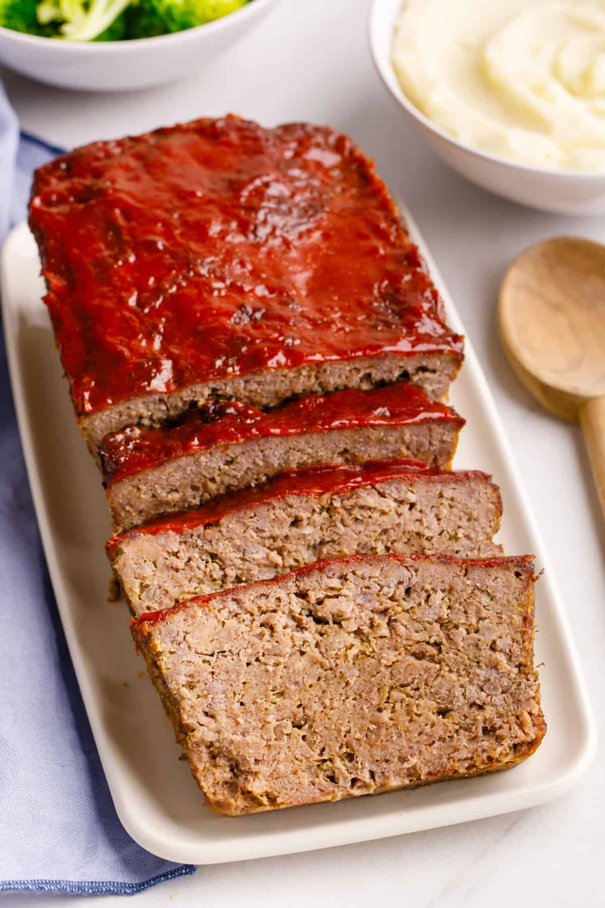 top down image of sliced cracker barrel meatloaf sitting on a rectangle white plate. 