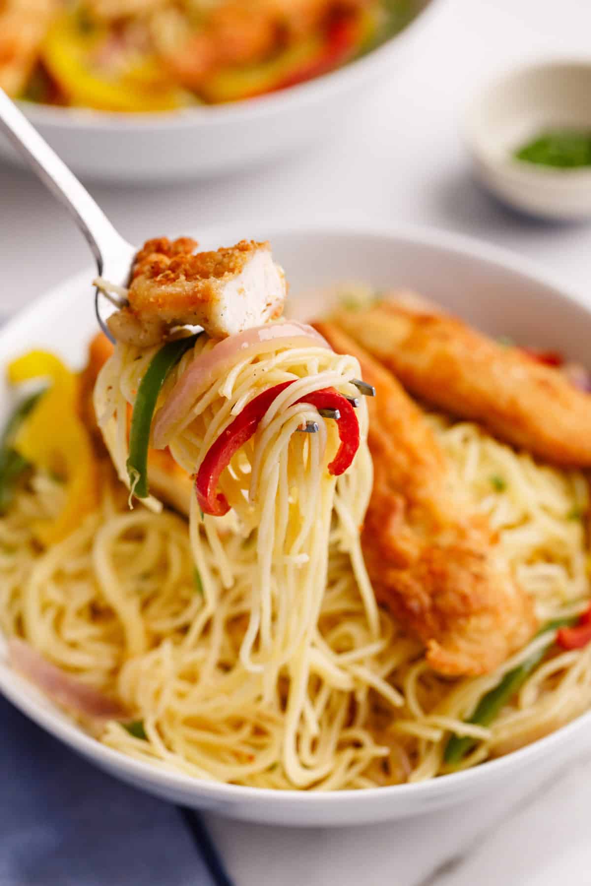 close up image of a forkful of olive garden chicken scampi.