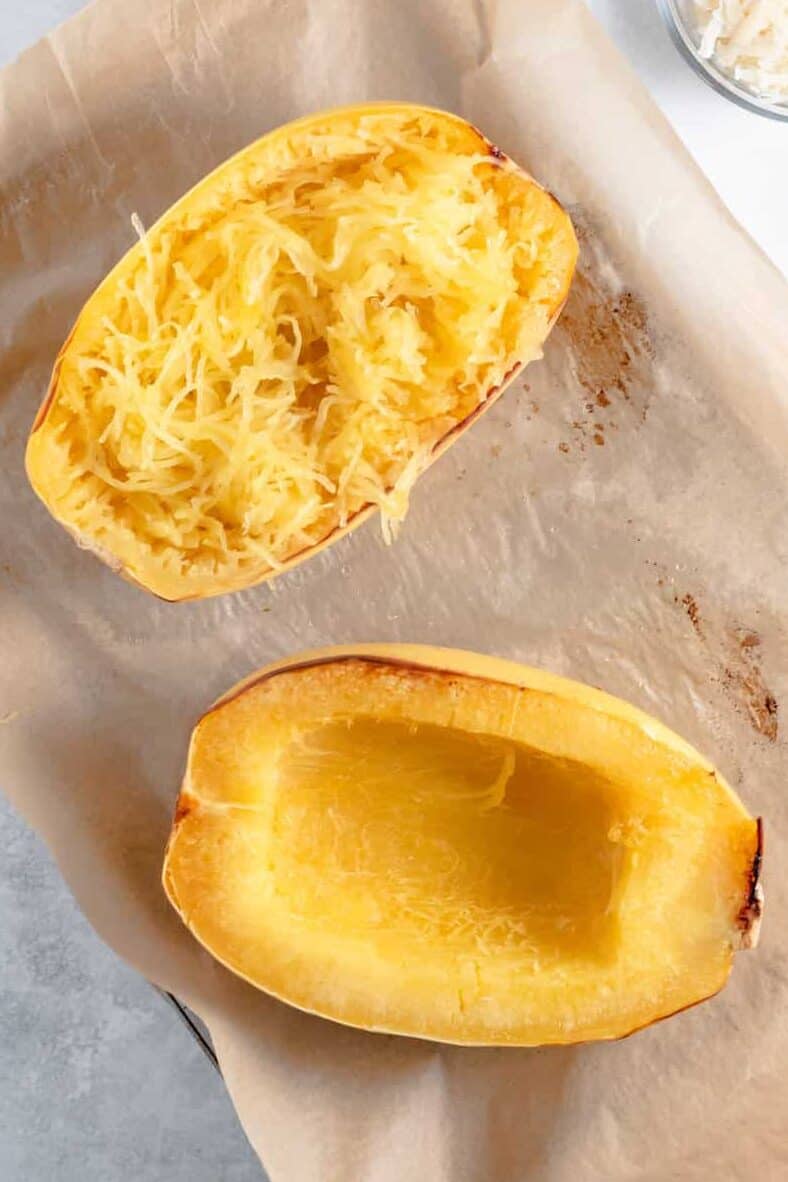 top down image of baked spaghetti squash sitting on a parchment lined baking sheet. 
