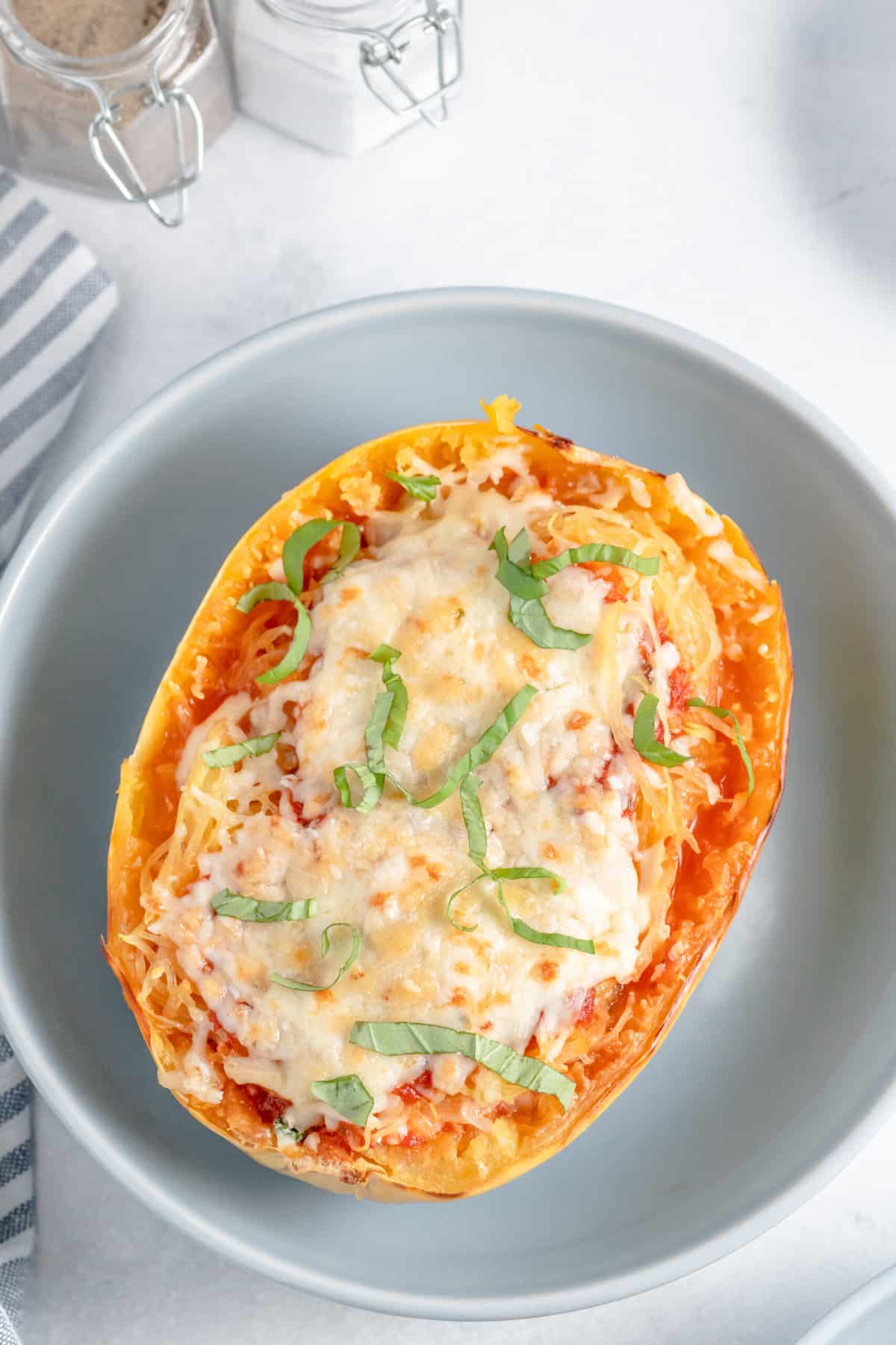 top down image of stuffed lasagna spaghetti squash served on a light grey plate.