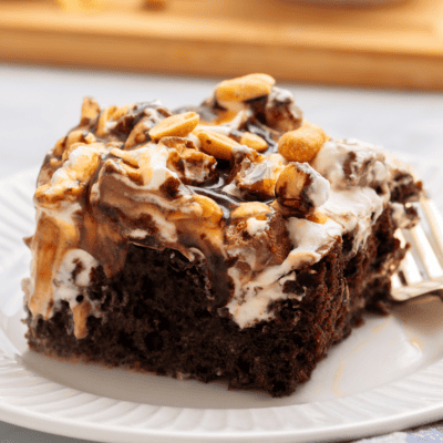 A slice of Snickers cake on a plate.